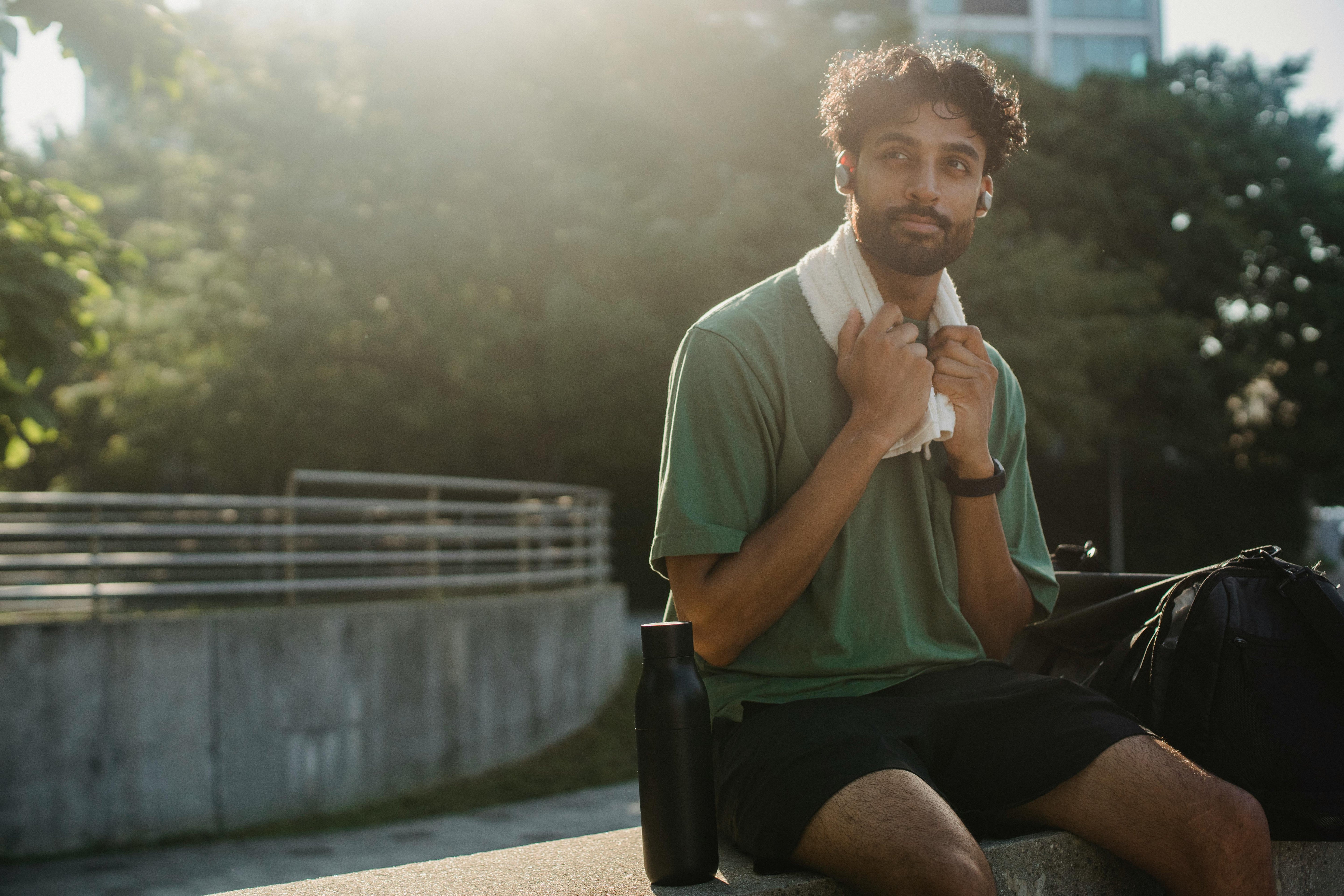 Young man resting after a workout outdoors, reflecting the everyday lifestyle habits that protect sperm count